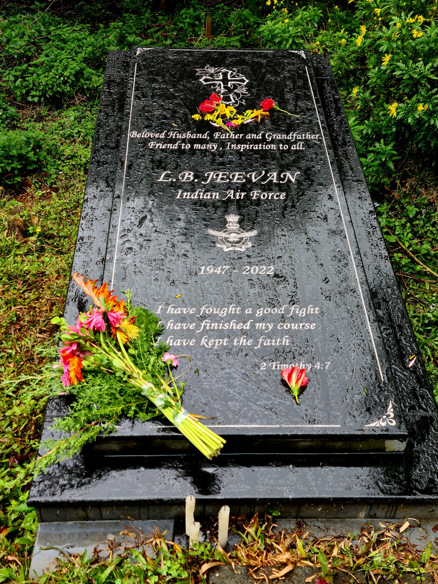 Black marble gravestone on which is written Beloved husband, father, and grandfather, friend to many, inspiration to all. L. B. Jeevan, Indian Air Force 1947-2022. I have fought a good fight, I have finished my course, I have kept the faith. 2 Timothy 4