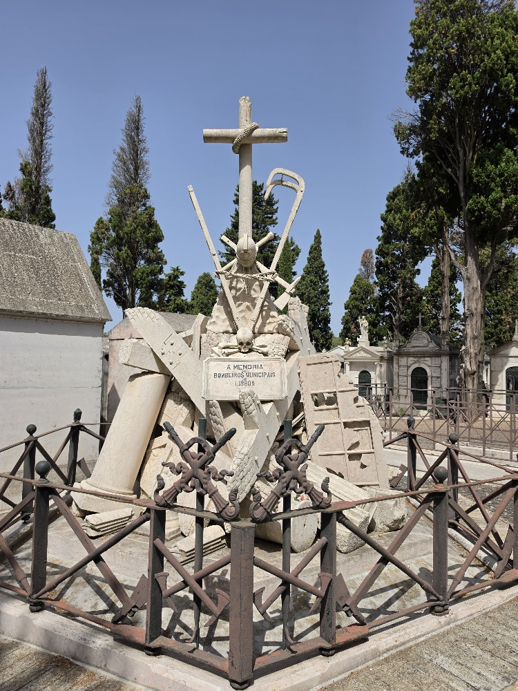 Monument to firefighters in Lisbon showing the ruins of a city topped by a cross featuring two skulls and crossbones